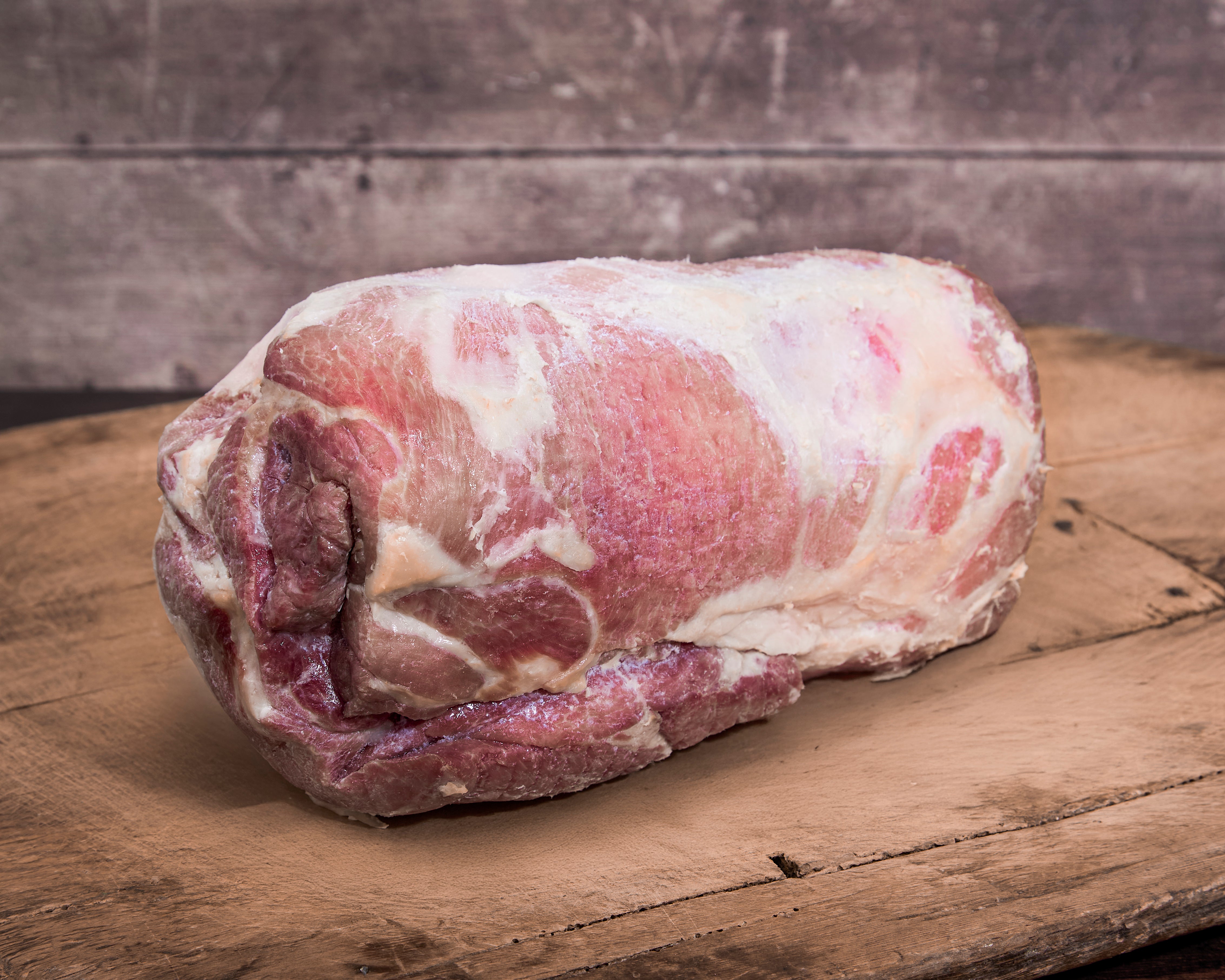 Cooked whole Turner Ham on a wooden cutting board